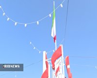 به اهتزاز در اوردن پرچم جمهوری اسلامی در میدان عاشورای کرمان